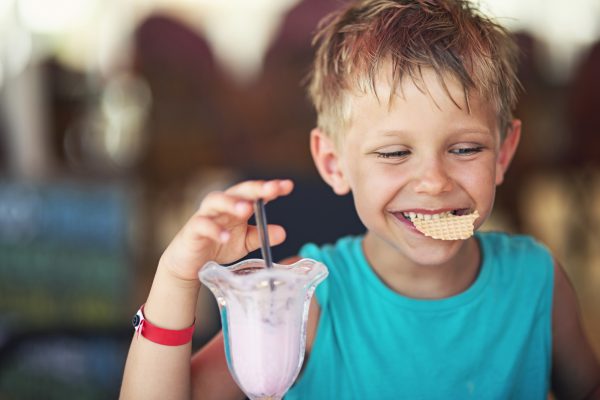 Little boy eating ice cream at restaurant